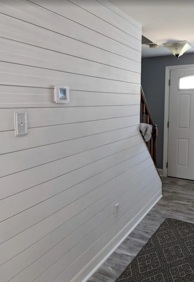 Finished white horizontal plank accent wall in an entryway